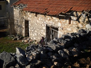 Una anciana reza el Rosario delante de su casa, en Medjugorje
