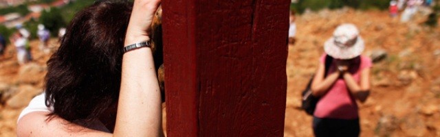 Oración en la cruz de madera de la Colina de las Apariciones en Medjugorje